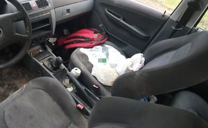 Bałagan we wnętrzu samochodu w rejonie fotelu pasażera.