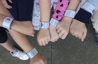 Dzieci prezentują ręce, na których mają założone odblaski.