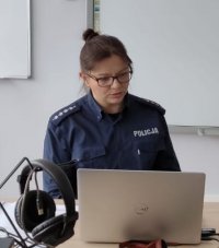 Policjantka w mundurze siedzi przy komputerze.