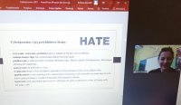 Screen z laptopa na którym jest policjantka w mundurze a obok plansza opisująca mowę nienawiści w internecie.