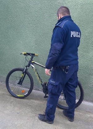 umundurowany policjant stoi obok roweru