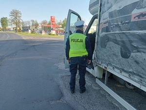 umundurowany policjant stoi obok busa