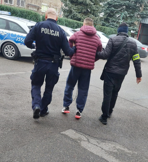 policjanci prowadzą zatrzymanego mężczyznę