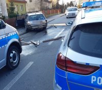 Dwa oznakowane radiowozy stoją przed rozbitym srebrnym audi.