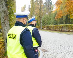 dwóch policjantów w kamizelkach odblaskowych na tle jesiennej aury