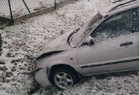 Biały samochód osobowy wjechał przodem do rowu  i uszkodził pokrywę silnika.