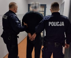 zatrzymany mężczyzna prowadzony przez policjantów