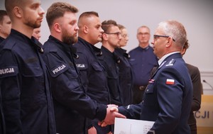 Zdjęcie przedstawia policjantów którzy ściskają sobie ręce.
