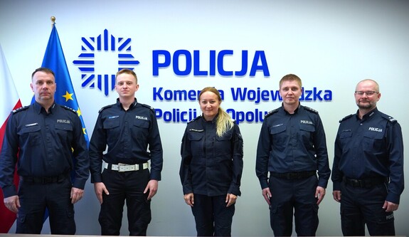 Zdjęcie kolorowe: na ścianie stoi 5 policjantów ustawionych do zdjęcia.